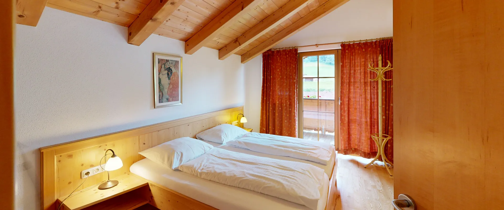 Schlafzimmer mit Holzdecke, zwei Betten und großer Fensterfront