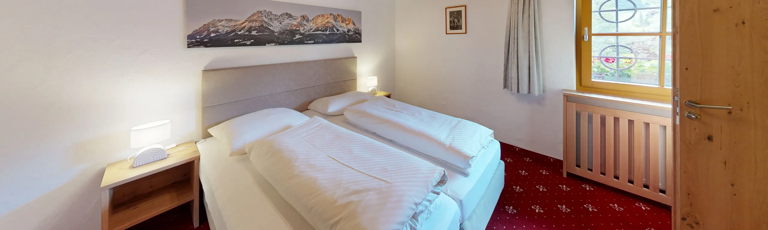 Zimmer mit zwei Betten, Fenster und Teppichboden
