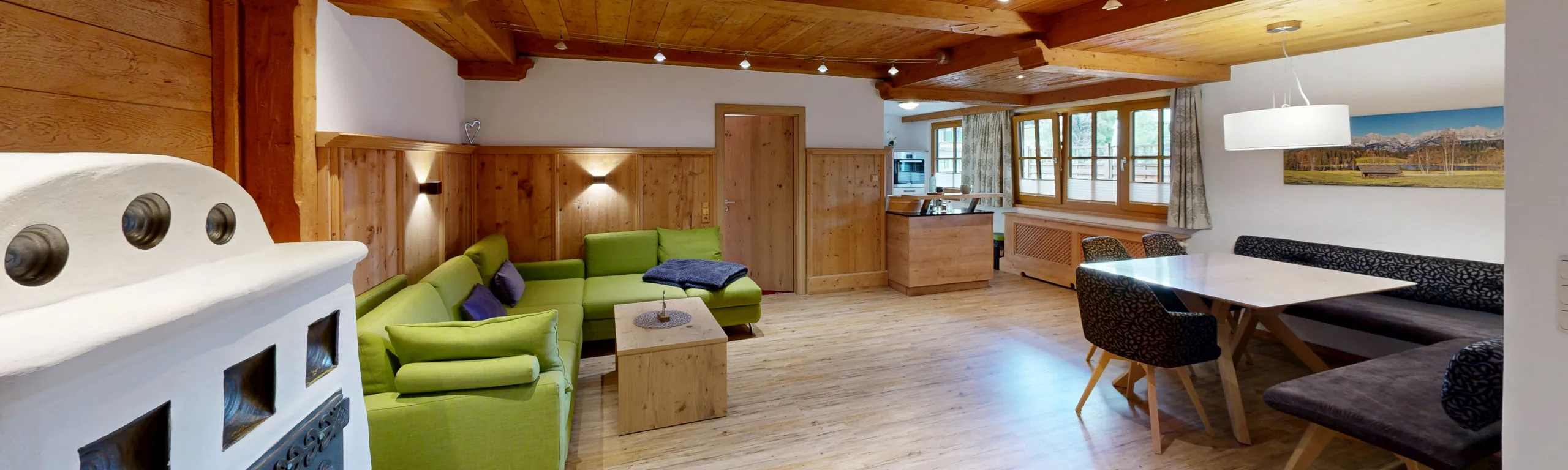 Wohnzimmer mit grünen Sofas und Holzmöbeln, gemütlich eingerichtet
