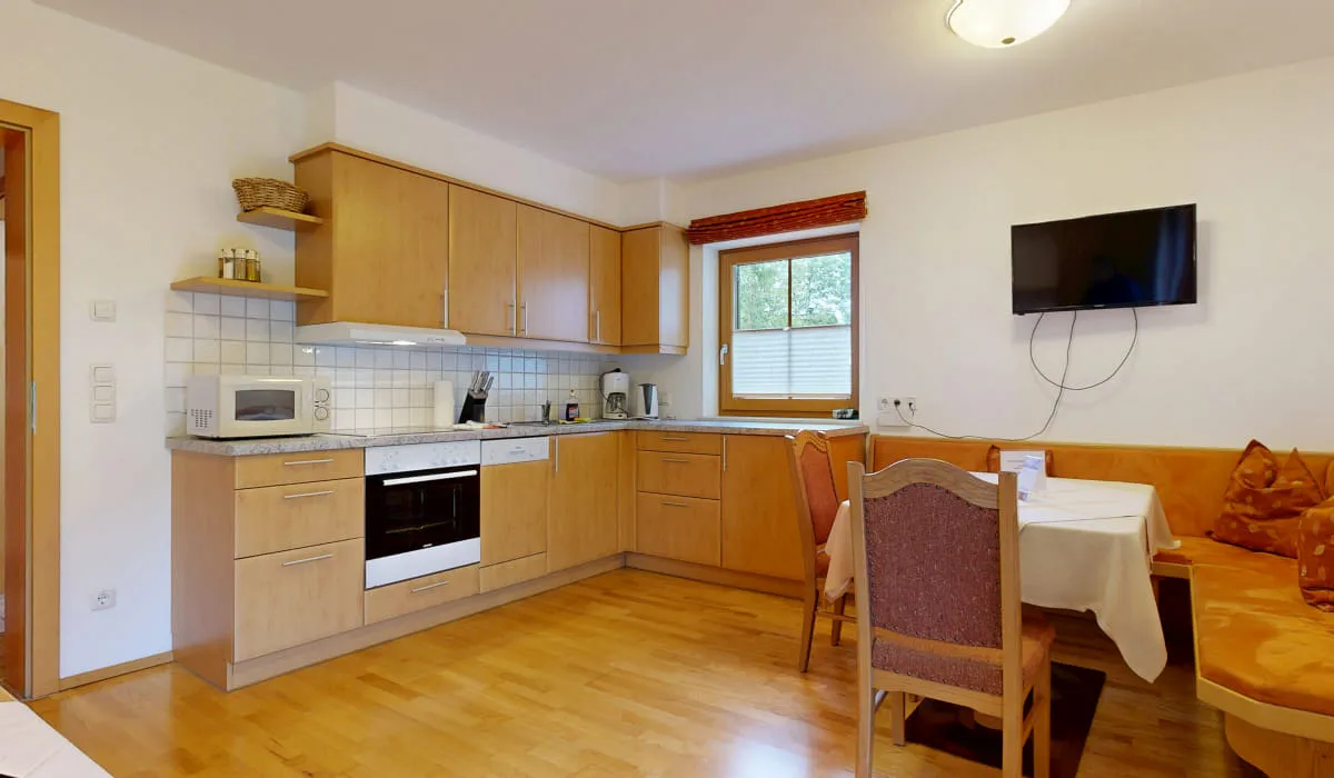 Küche mit Esstisch und Fernseher in einer Wohnung