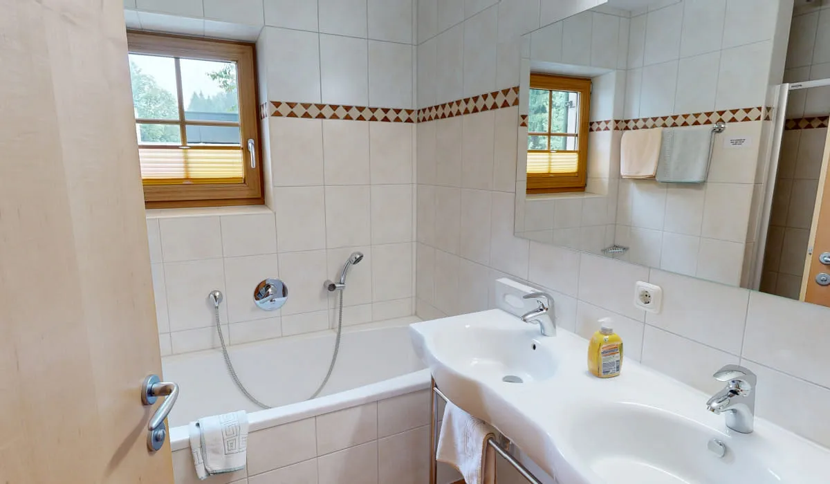 Badezimmer mit Badewanne und Doppelwaschbecken