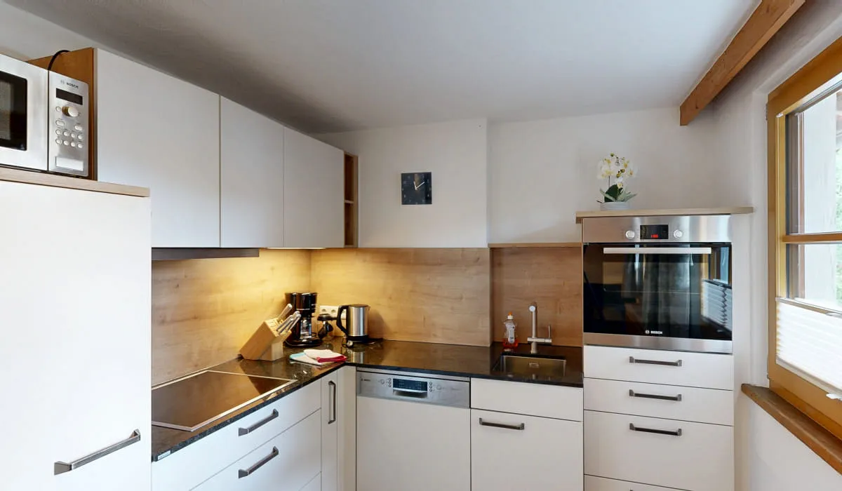 Moderne Küche mit weißen Schränken und Holzdetails