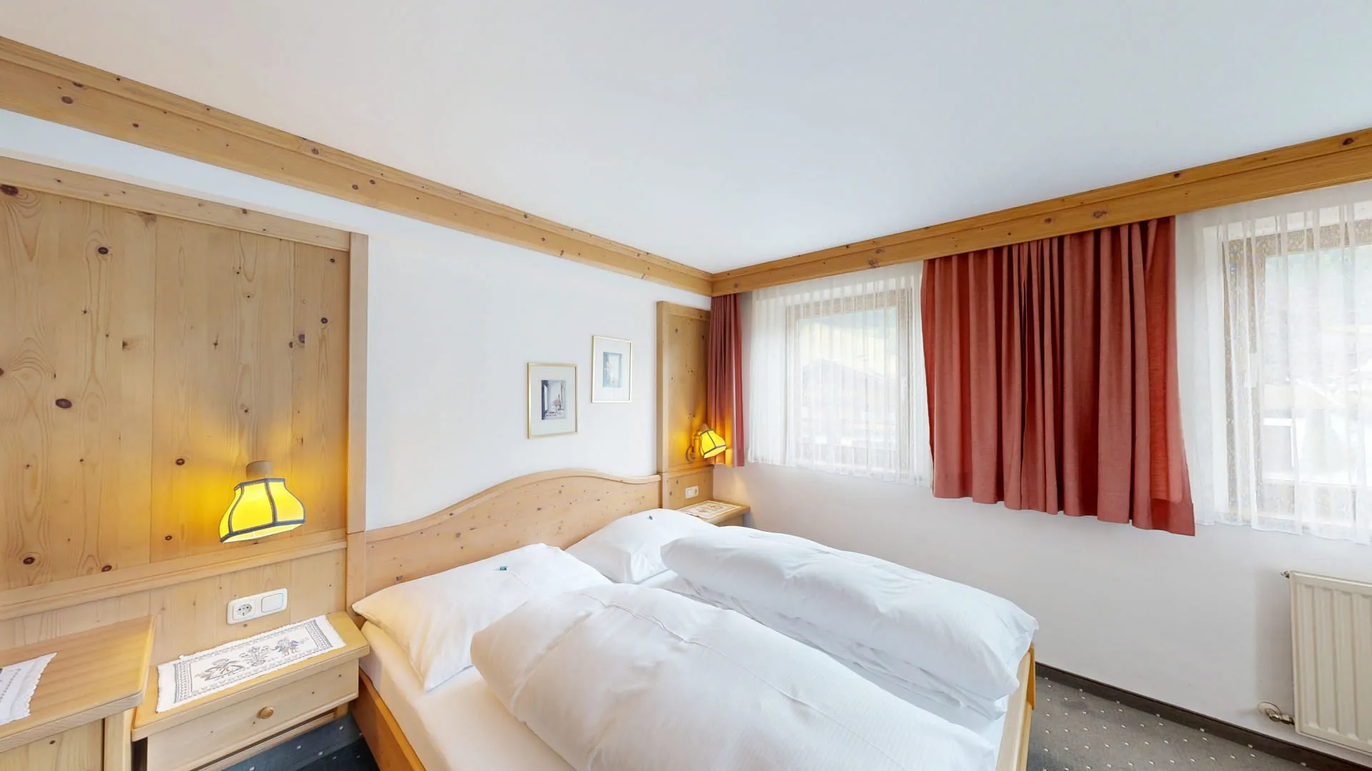 Helles Schlafzimmer mit Holzdetails und rotem Vorhang