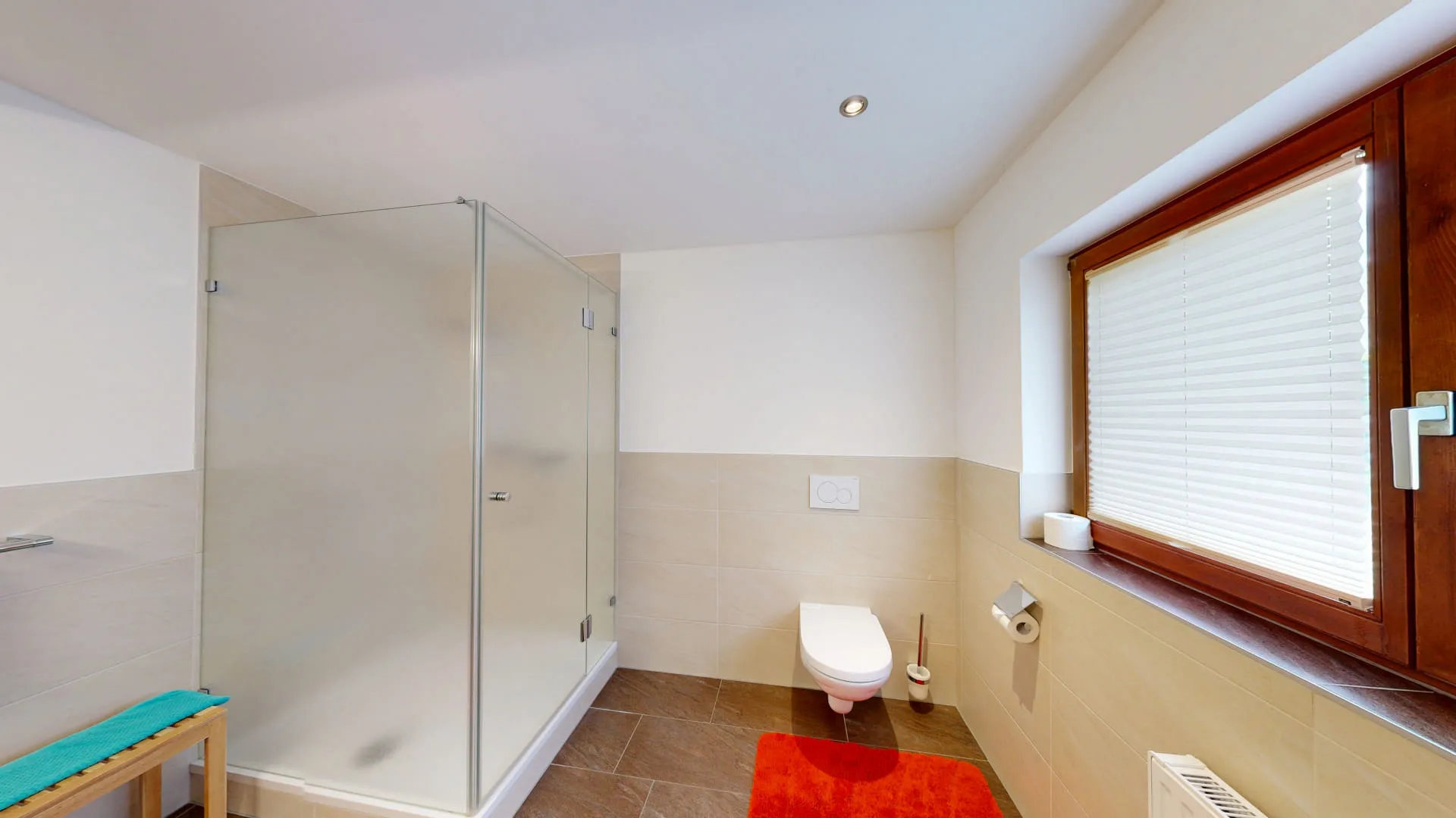 Badezimmer mit Dusche, Toilette und Fenster