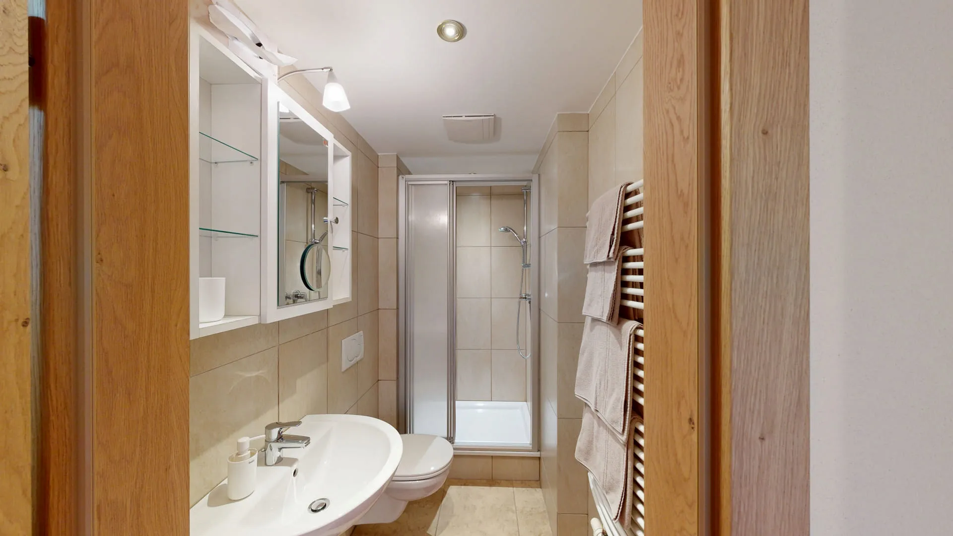 Helles Badezimmer mit Dusche und Handtüchern